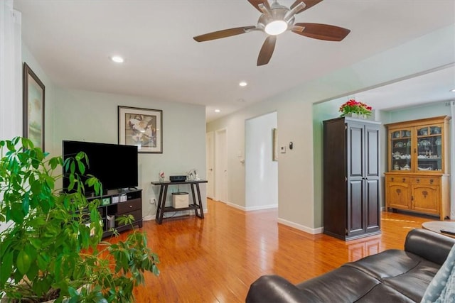 living room featuring light wood-type flooring and ceiling fan