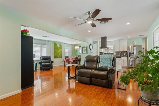 living room with ceiling fan and light wood-type flooring