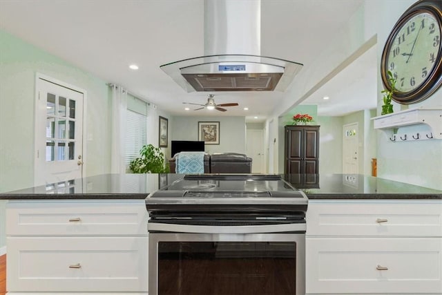 kitchen featuring ceiling fan, island range hood, white cabinetry, and stainless steel range with electric cooktop