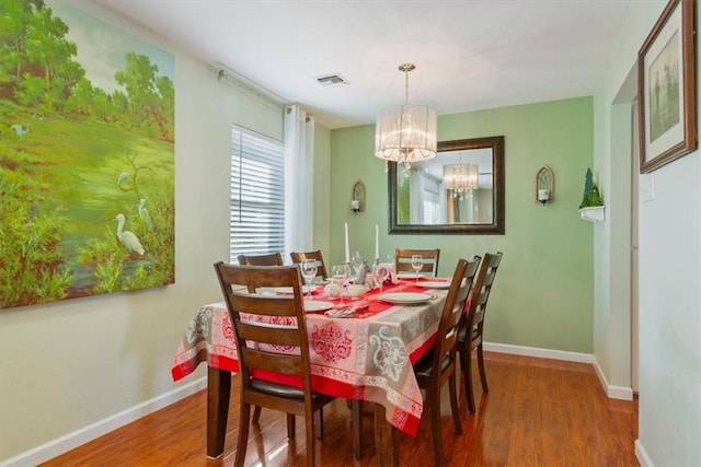 dining space featuring a chandelier and wood-type flooring