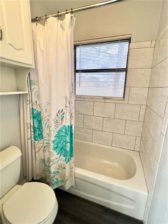 bathroom featuring wood-type flooring, shower / bath combo, and toilet