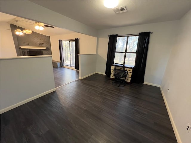 spare room featuring plenty of natural light, lofted ceiling, and dark wood-type flooring