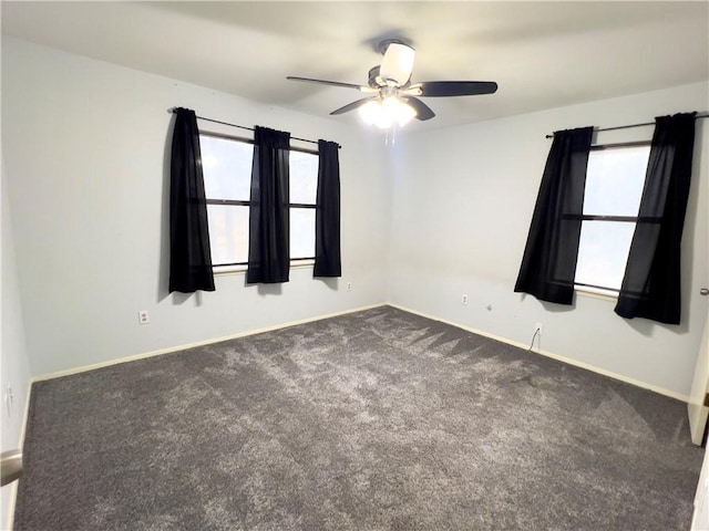 carpeted spare room featuring ceiling fan