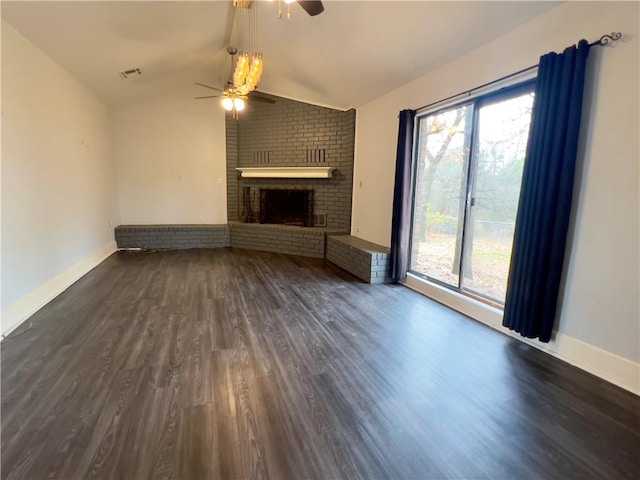 unfurnished living room featuring vaulted ceiling, plenty of natural light, and dark wood-type flooring