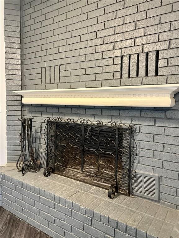 details featuring hardwood / wood-style flooring and a brick fireplace