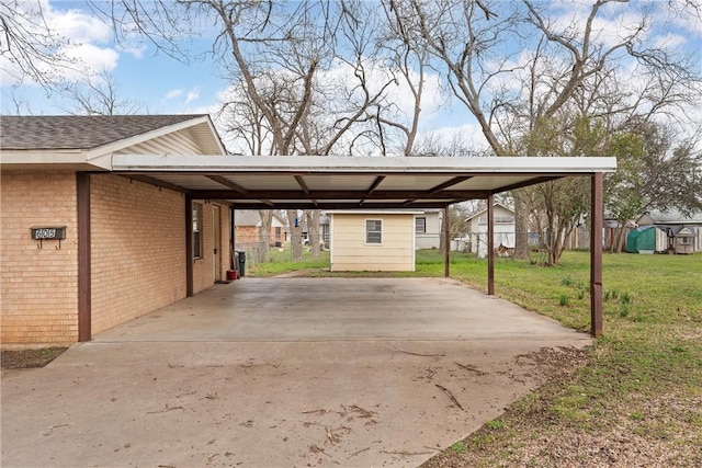 view of vehicle parking with a carport, fence, and driveway