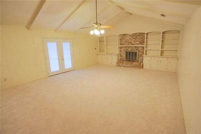 unfurnished living room with carpet, french doors, lofted ceiling with beams, built in features, and a fireplace