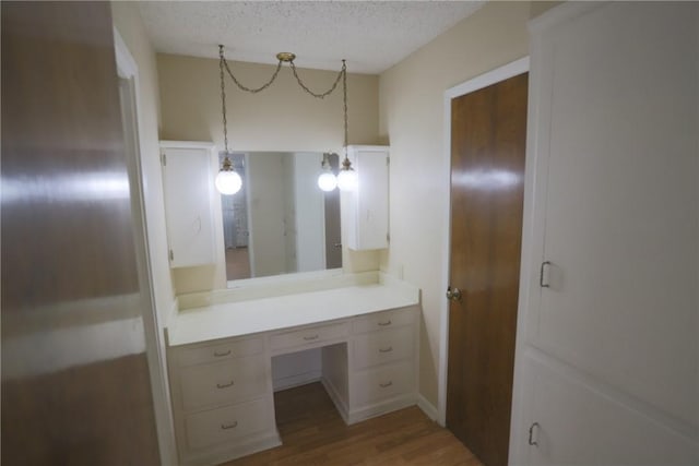 bathroom featuring hardwood / wood-style floors, vanity, and a textured ceiling