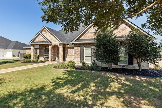 view of front of home featuring brick siding, stone siding, and a front lawn