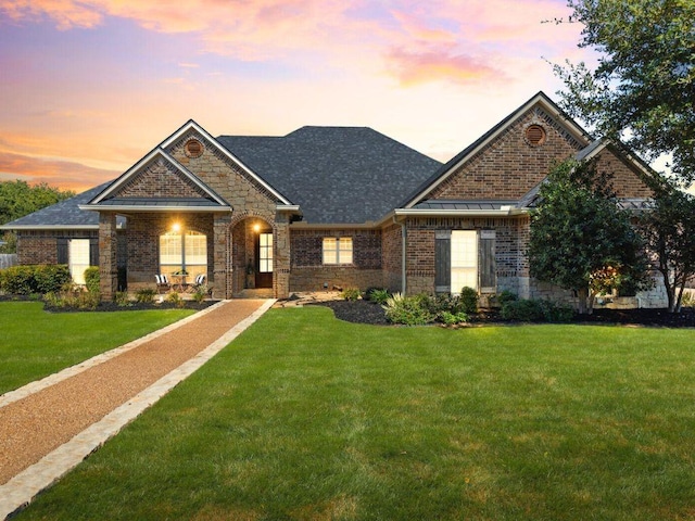 craftsman-style home with a yard and brick siding