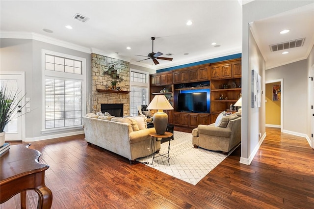 living room featuring hardwood / wood-style floors, visible vents, and ornamental molding