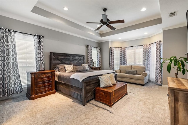 bedroom with a tray ceiling, recessed lighting, crown molding, and visible vents