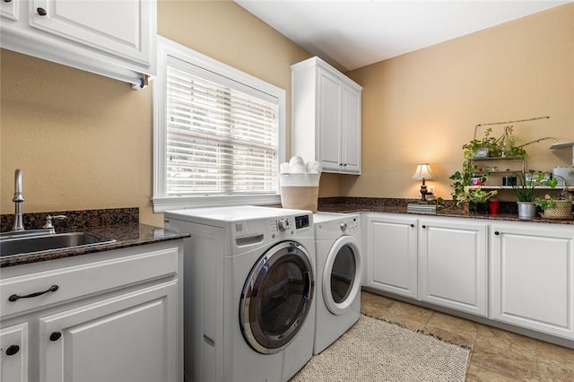 laundry area with cabinet space, independent washer and dryer, and a sink