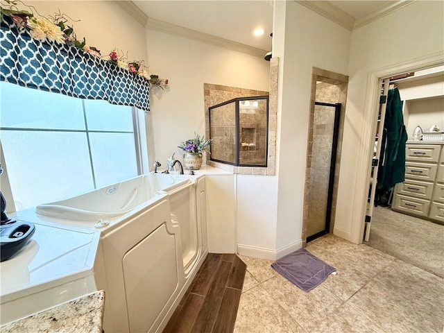 bathroom with washing machine and clothes dryer, ornamental molding, and separate shower and tub