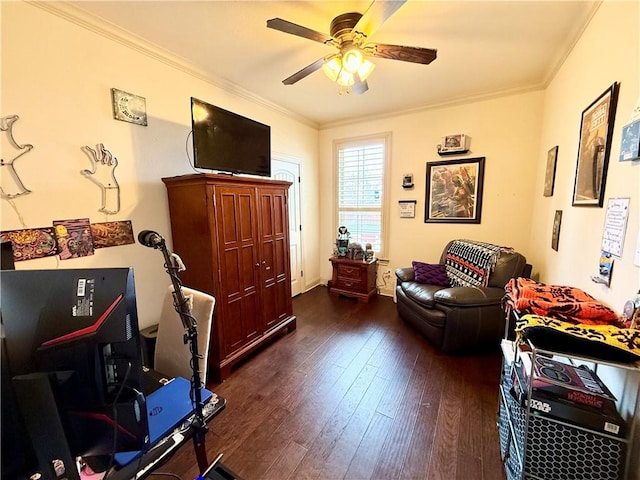 sitting room with ornamental molding, dark wood-type flooring, and ceiling fan