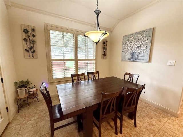 tiled dining space featuring crown molding and vaulted ceiling