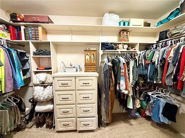 walk in closet featuring light colored carpet