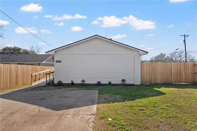 view of side of home with a patio and a yard