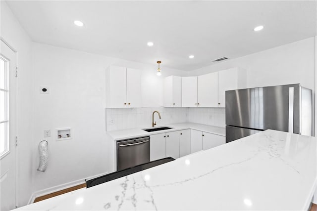 kitchen featuring tasteful backsplash, appliances with stainless steel finishes, sink, and white cabinets