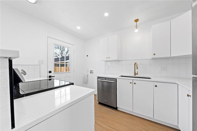 kitchen with dishwasher, sink, white cabinets, backsplash, and light wood-type flooring