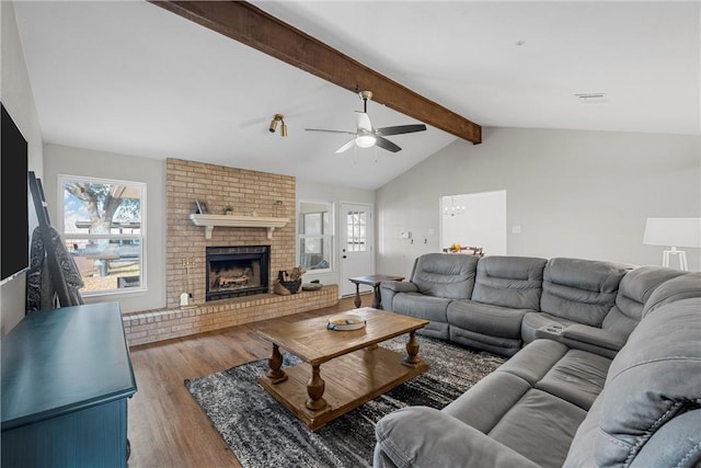 living room with ceiling fan, hardwood / wood-style floors, a fireplace, and lofted ceiling with beams