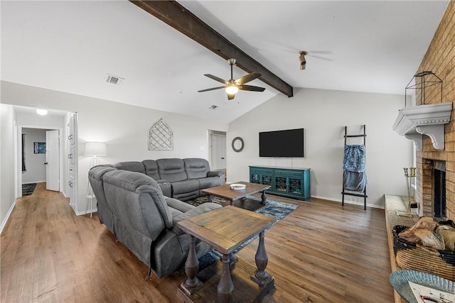 living room with a fireplace, hardwood / wood-style floors, vaulted ceiling with beams, and ceiling fan