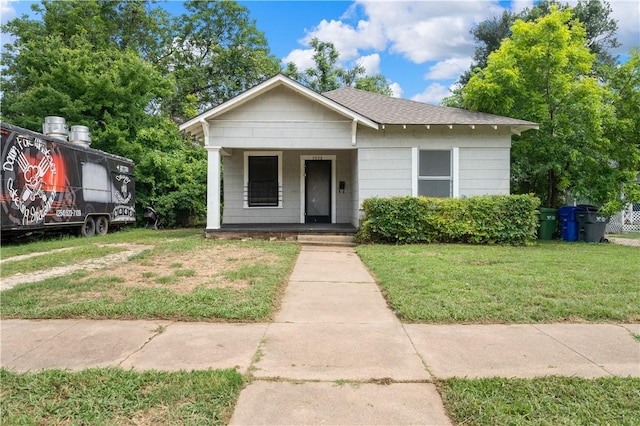 bungalow with a front lawn and covered porch