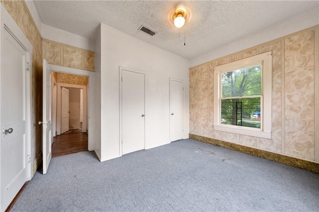 unfurnished bedroom with ceiling fan, carpet floors, and a textured ceiling