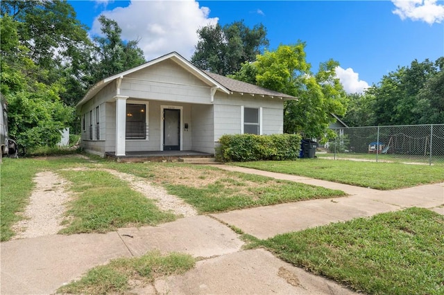 bungalow with covered porch and a front lawn