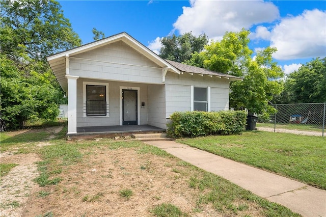 bungalow with covered porch and a front lawn