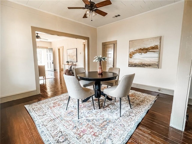 dining space featuring ornamental molding and dark wood-type flooring