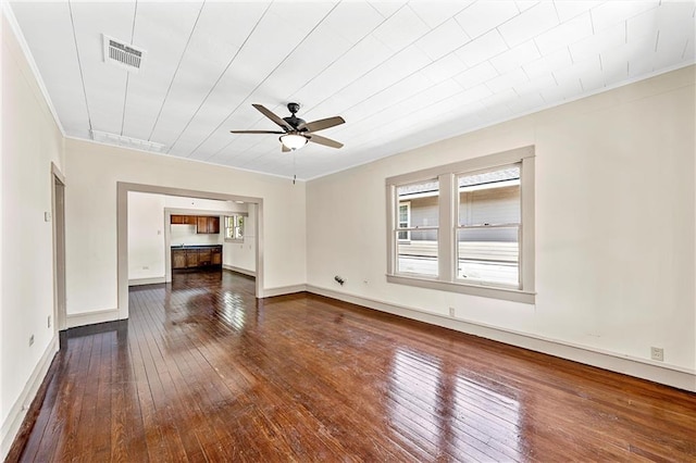 unfurnished living room with dark hardwood / wood-style floors, ceiling fan, and ornamental molding