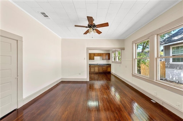 unfurnished living room featuring dark hardwood / wood-style flooring, ceiling fan, and ornamental molding