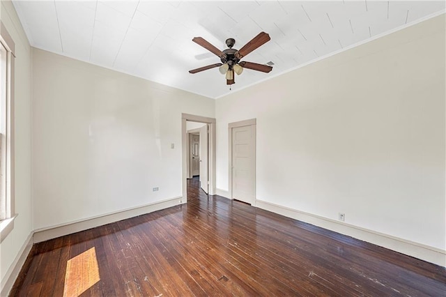 empty room with ceiling fan, dark hardwood / wood-style flooring, and crown molding