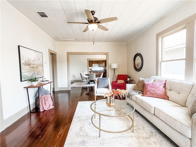 living room with dark hardwood / wood-style floors, ceiling fan, ornamental molding, and wood ceiling