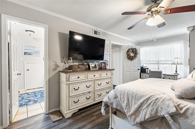 bedroom featuring dark hardwood / wood-style flooring, ceiling fan, and crown molding