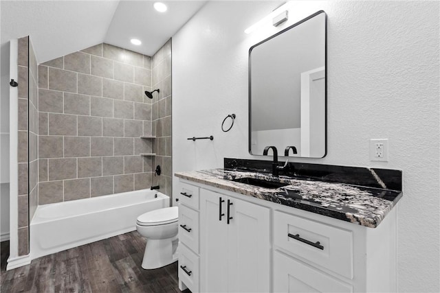 full bathroom with toilet, vaulted ceiling, shower / bathing tub combination, wood finished floors, and vanity