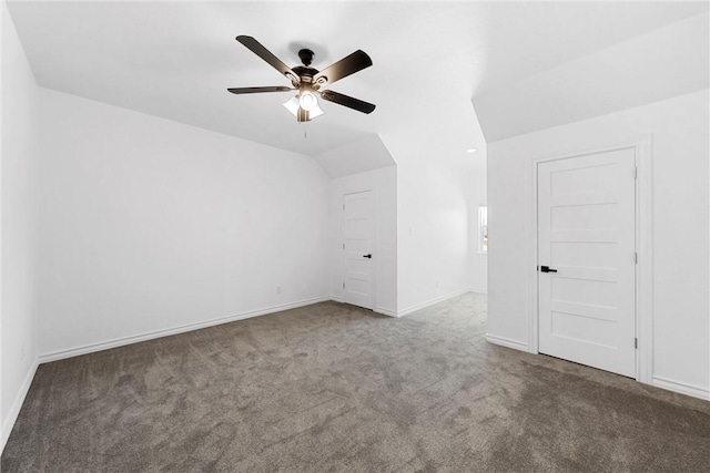 interior space featuring baseboards, a ceiling fan, carpet flooring, and vaulted ceiling