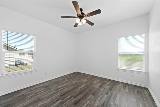 spare room with plenty of natural light, ceiling fan, baseboards, and dark wood-style flooring