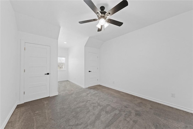 interior space with vaulted ceiling, ceiling fan, baseboards, and carpet floors