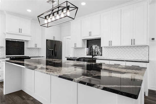 kitchen with custom exhaust hood, black fridge, dark wood-style floors, white cabinets, and a sink