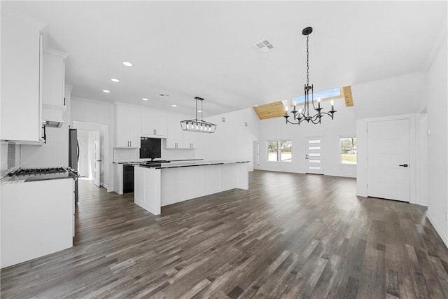 kitchen featuring visible vents, a center island, a chandelier, decorative backsplash, and white cabinets