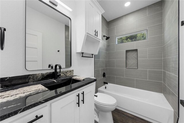 bathroom with vanity, toilet, shower / bathing tub combination, and wood finished floors