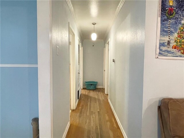 corridor with hardwood / wood-style flooring and crown molding