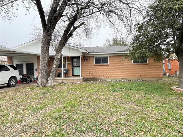 ranch-style home featuring cooling unit and a front yard