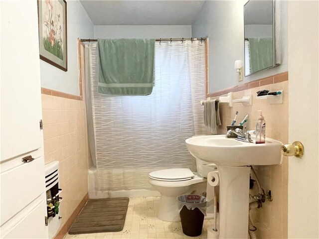 bathroom with tile walls and toilet