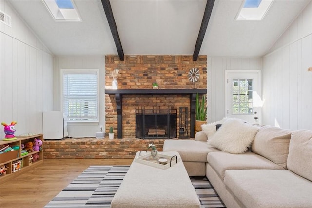 living room with a fireplace, wood finished floors, and vaulted ceiling with beams