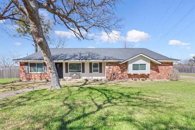 single story home featuring a front lawn, fence, and brick siding