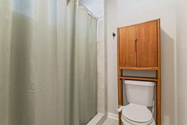 bathroom featuring curtained shower and toilet