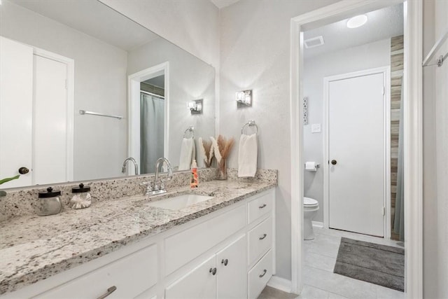 bathroom featuring visible vents, toilet, vanity, and tile patterned flooring